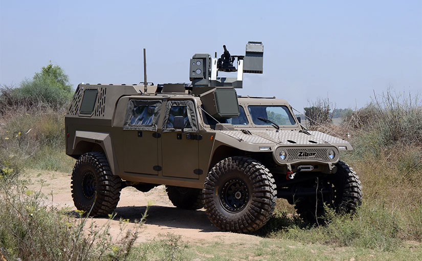 Armored off-road vehicle with mounted sensor turret on a dirt track