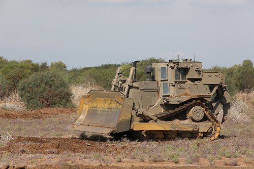 Armored bulldozer working on open terrain