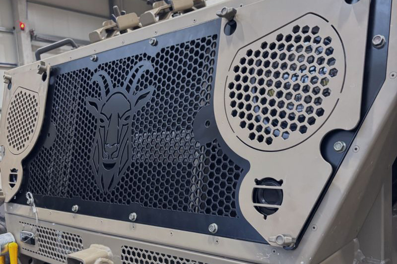 Close-up of a vehicle front grille with a goat emblem