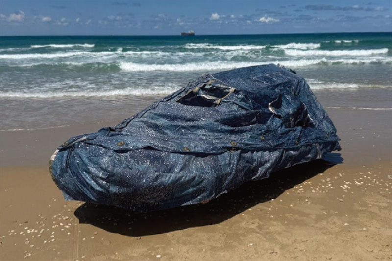 Boat hidden under a camouflage cover on a beach