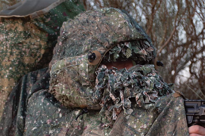 Soldier wearing a camouflage poncho with hood