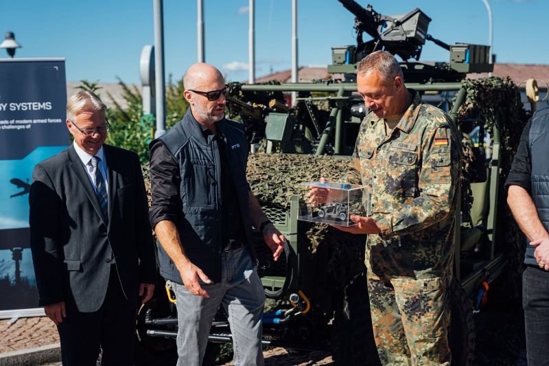 Men in suits and uniform at a handover in front of a vehicle